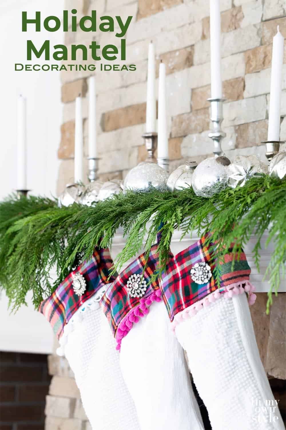 Winter fireplace mantel decorated with candles and silver ornaments