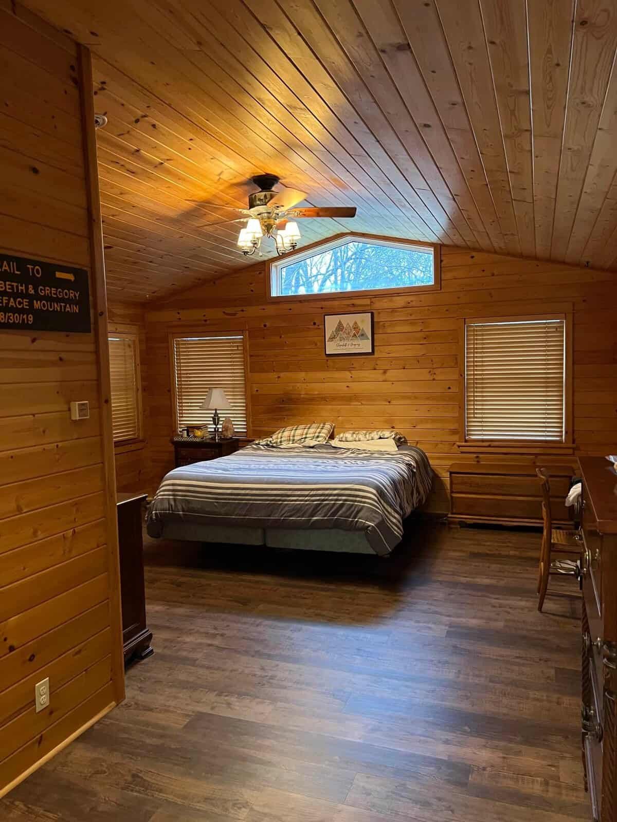 Cozy cabin lodge style winter bedroom with wood paneling