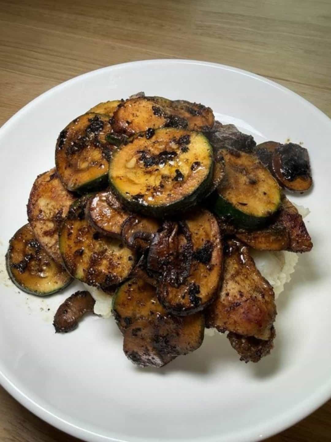 Blackened chicken with seared zucchini and mushrooms over rice