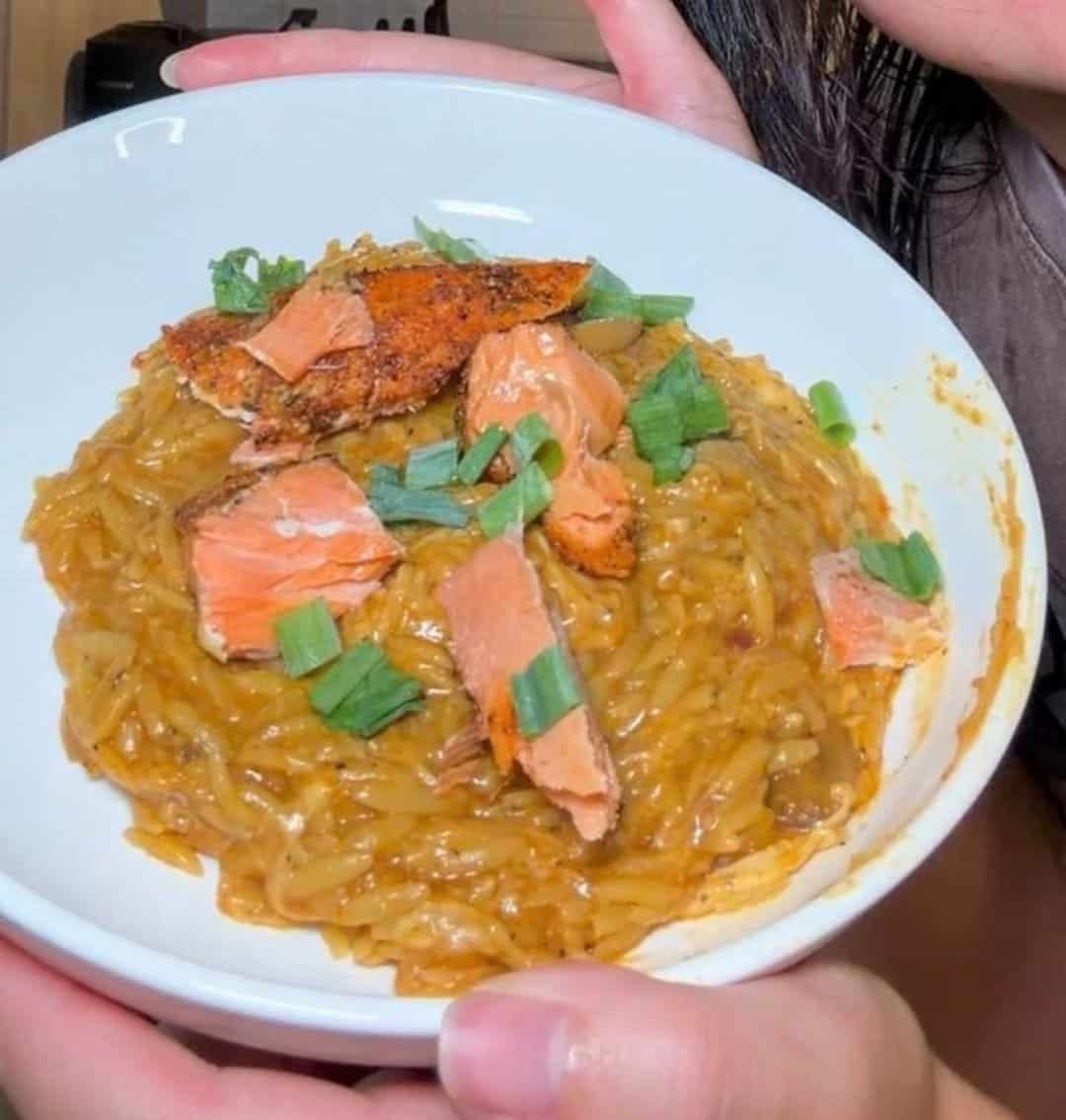 Blackened salmon with gochujang pesto orzo topped with green onions