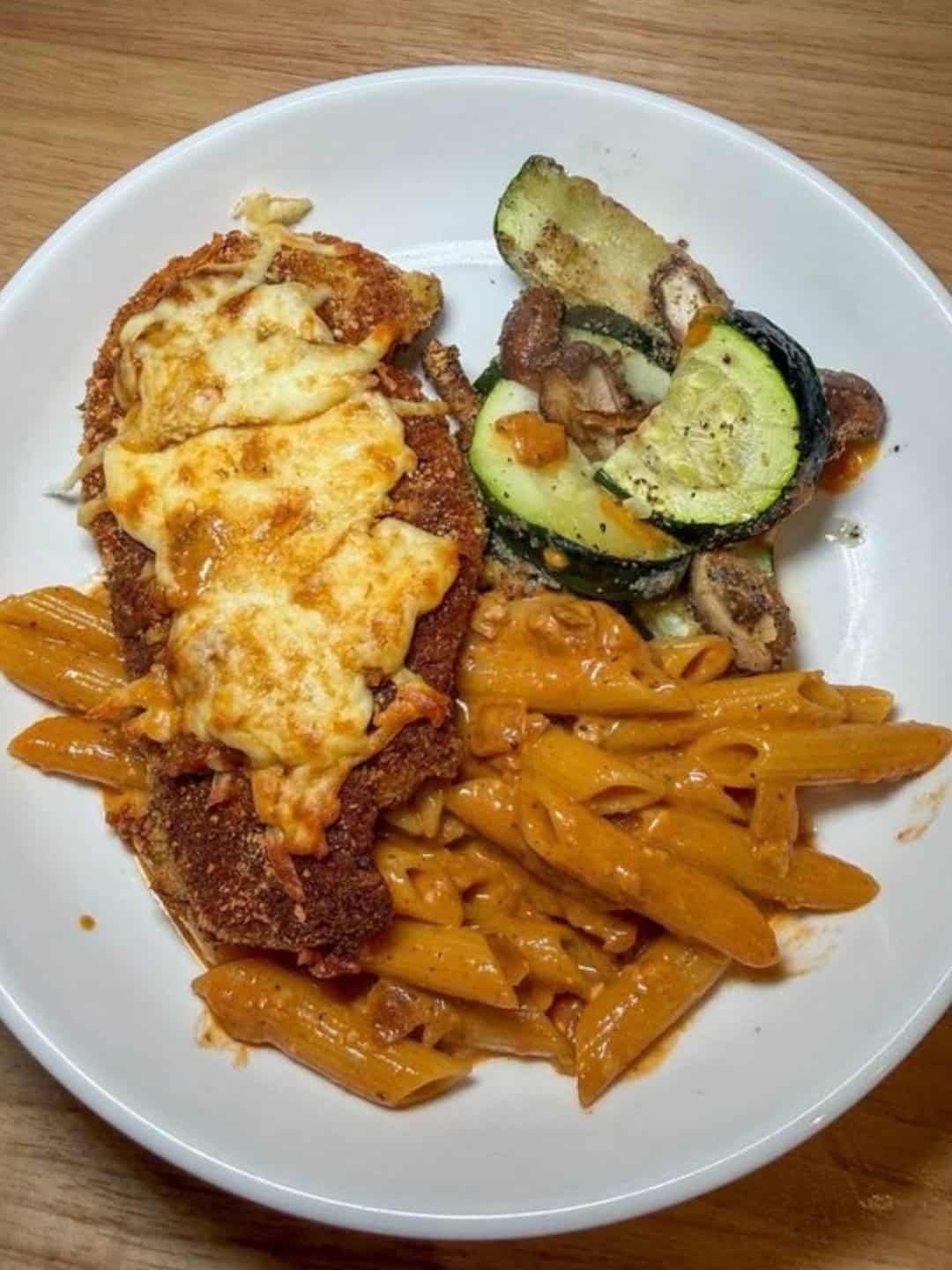 Crispy chicken parmesan with rose penne and sauteed zucchini and mushrooms