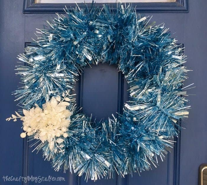 Winter wreath with garland hung on front door entryway