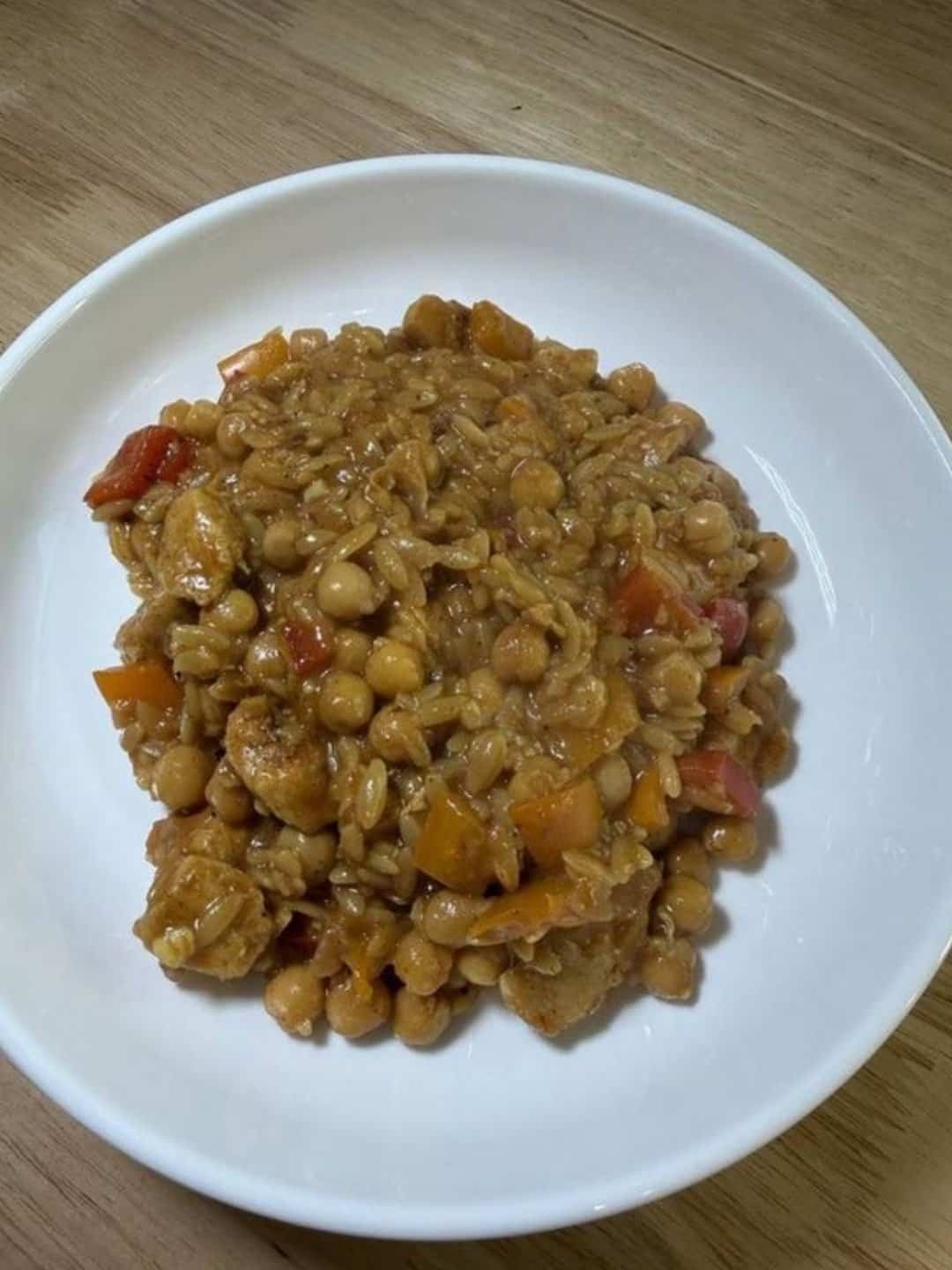 One pot chicken and chickpea orzo with bell peppers in a white bowl