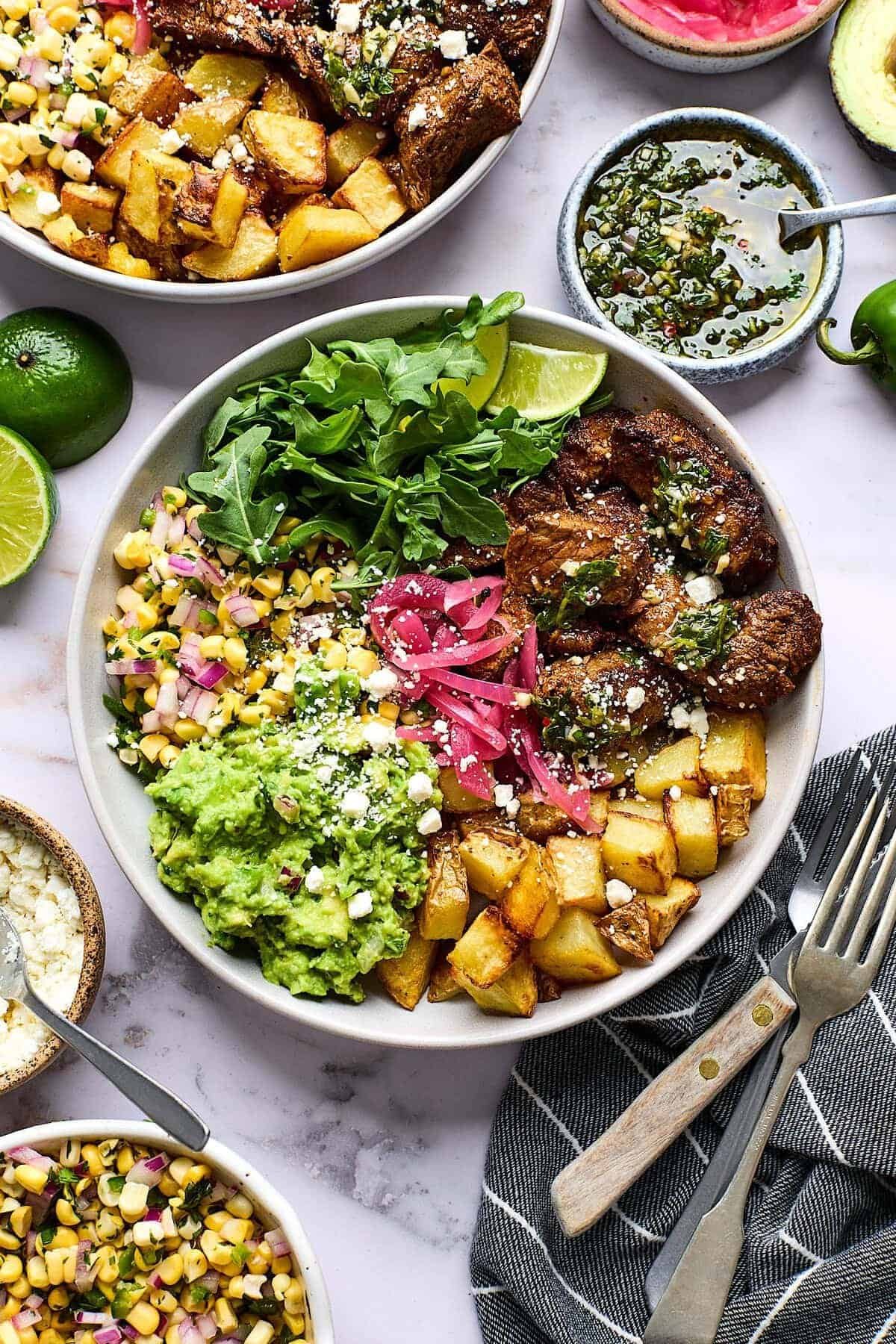 Loaded steak bowls with crispy potatoes and chimichurri