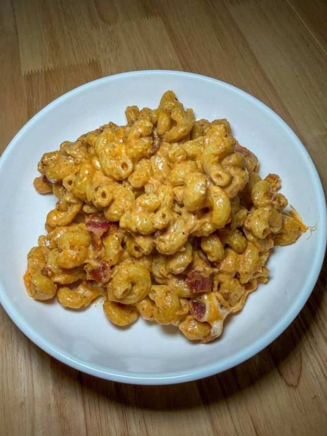 Creamy spicy bacon mac and cheese in a white bowl