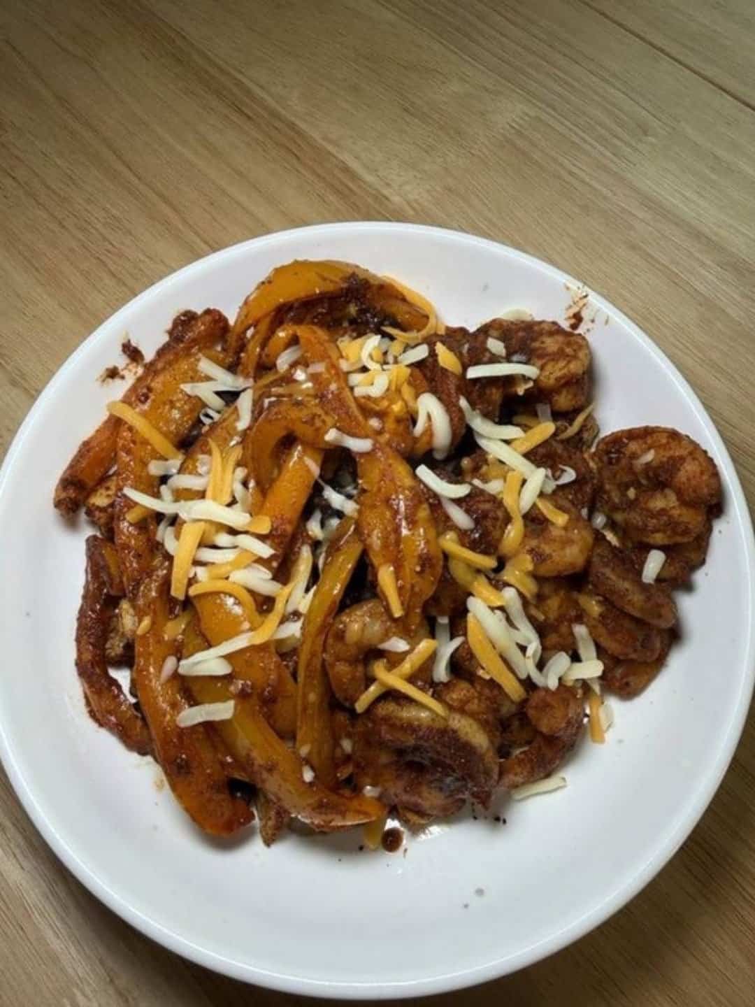 Spicy shrimp fajita bowl with bell peppers and shredded cheese