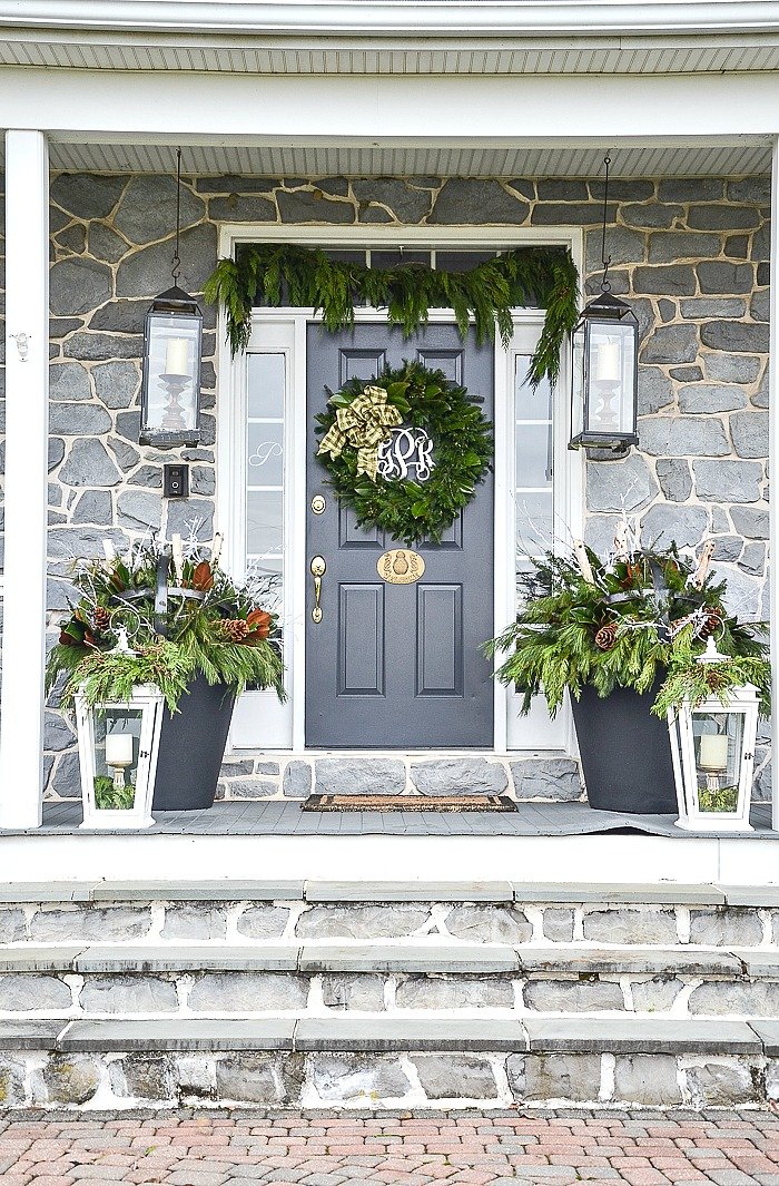 Front door with matching Christmas planters filled with birch logs, magnolia leaves and evergreens