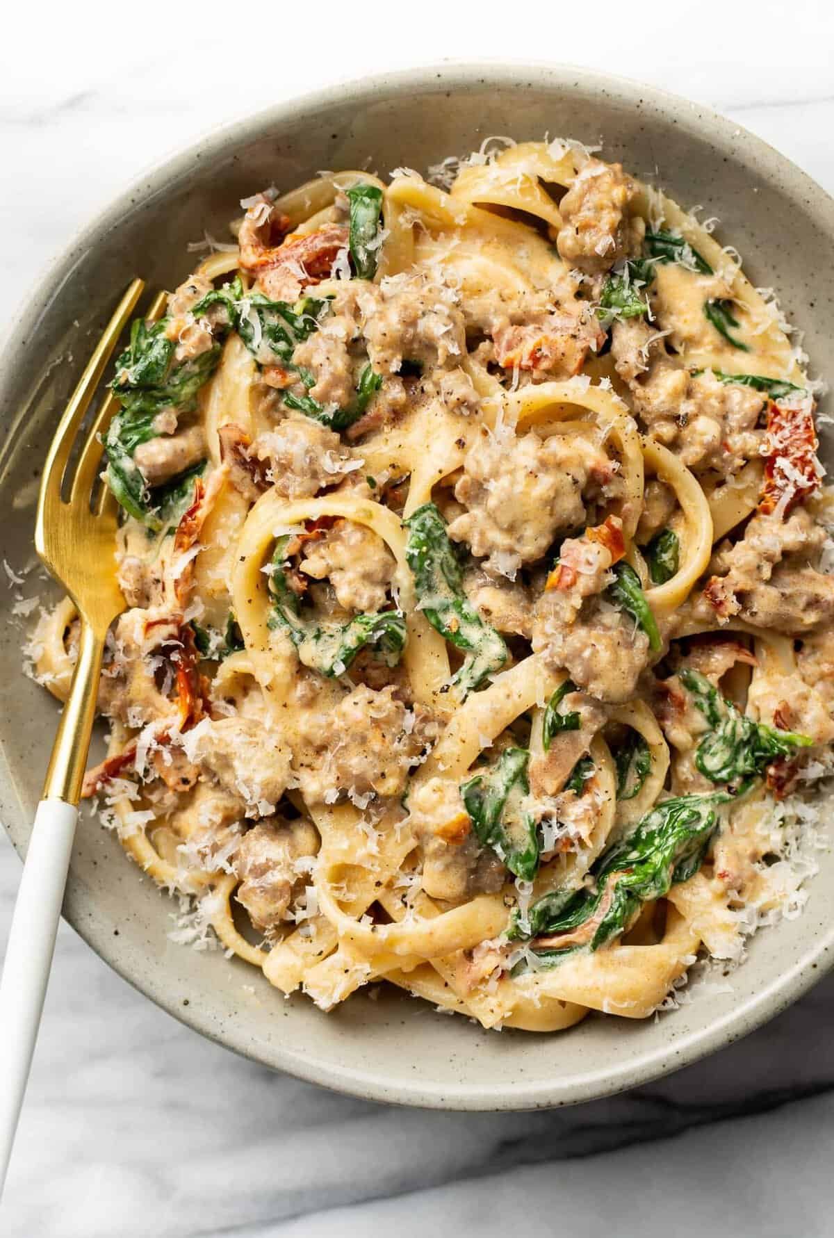 Creamy Tuscan sausage pasta in a skillet
