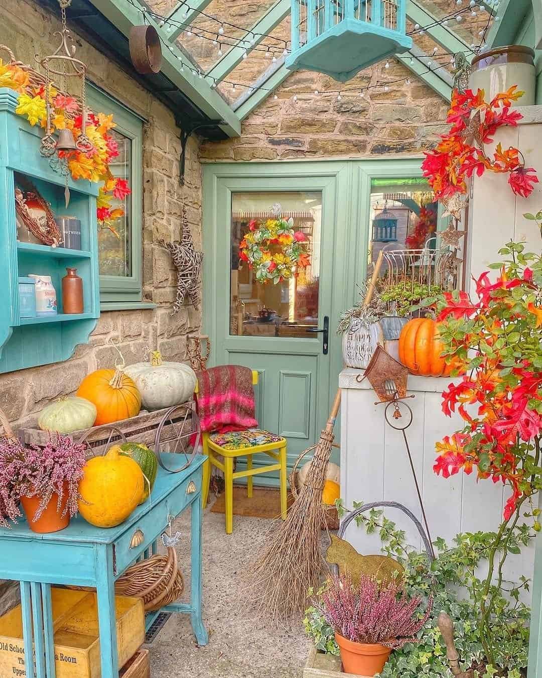 Stone porch with mint green trim, pumpkins, orange leaves and vintage painted furniture