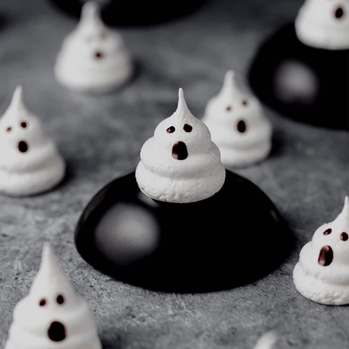 White ghost meringue cookies with chocolate faces