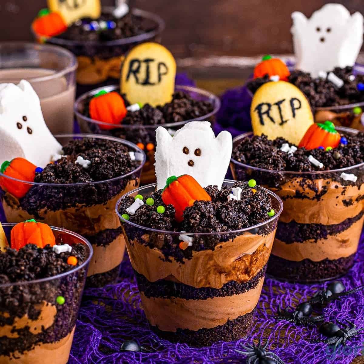 Halloween graveyard dirt cups with cookie tombstones, ghosts and gummy worms