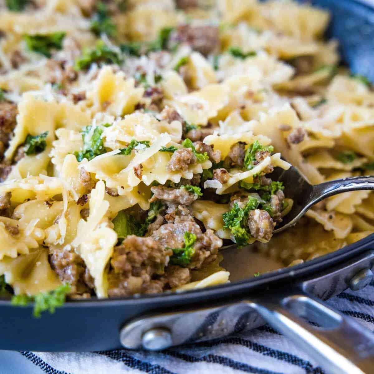 Spaghetti with kale and sausage in a skillet