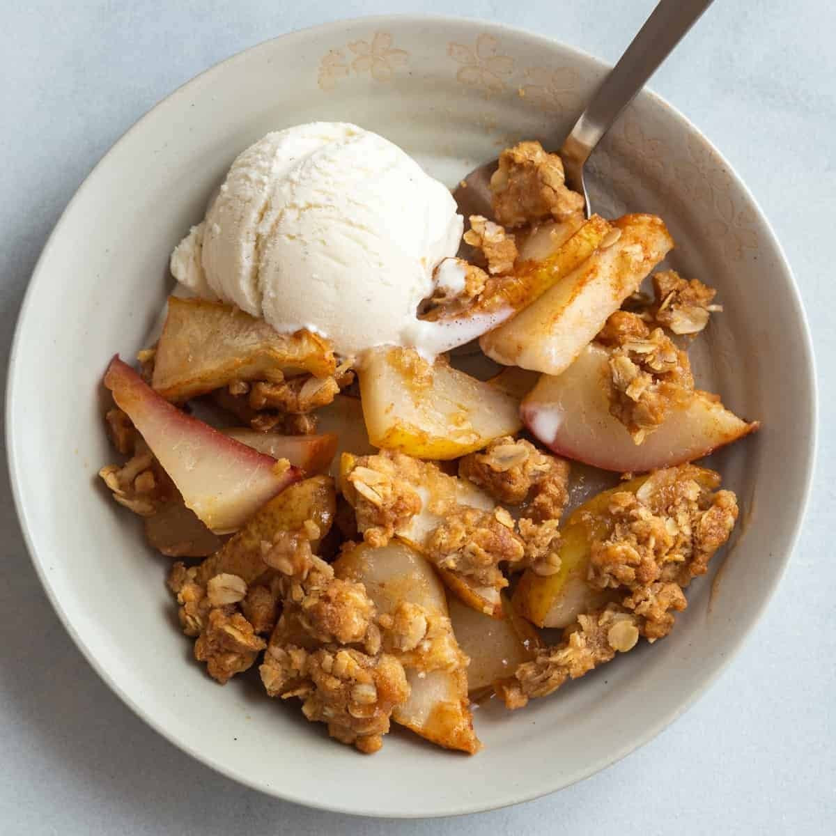 Pear crisp with oat topping and vanilla ice cream