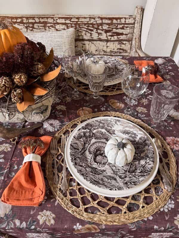 Farmhouse Thanksgiving table with turkey plates, plum tablecloth and burnt orange napkins