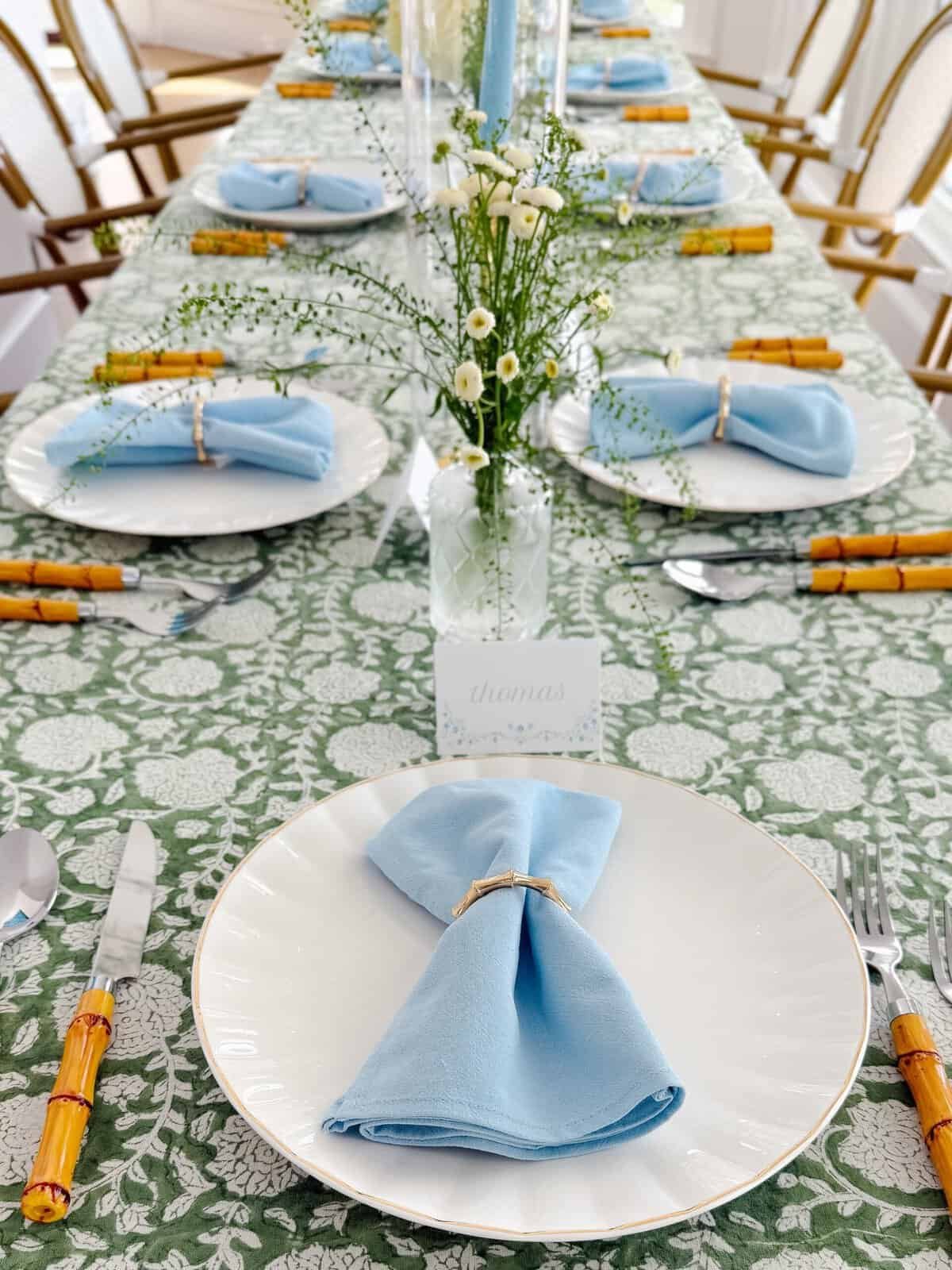 Green and blue Thanksgiving tablescape with a floral block print tablecloth and white roses