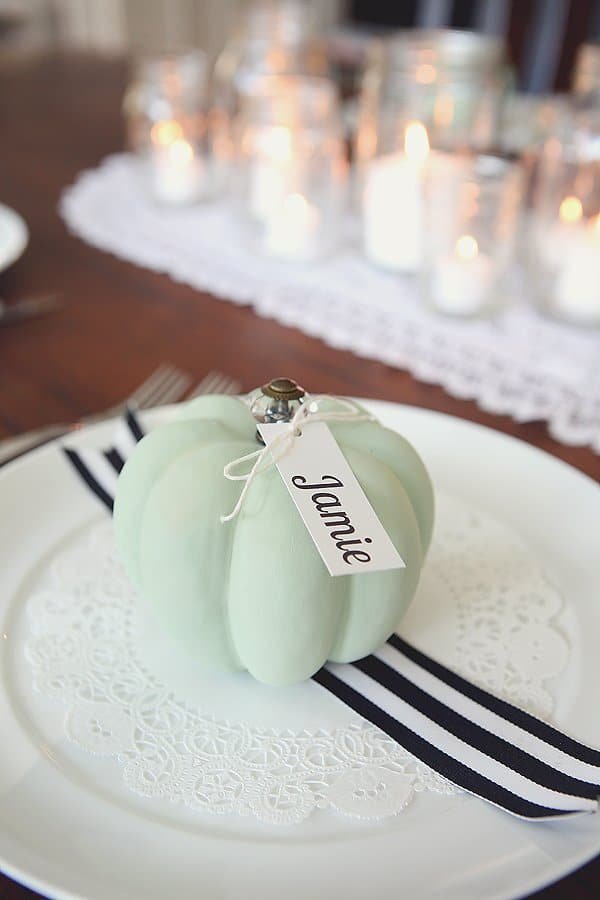 Blue grey chalk painted pumpkins with name tags on white plates with doilies