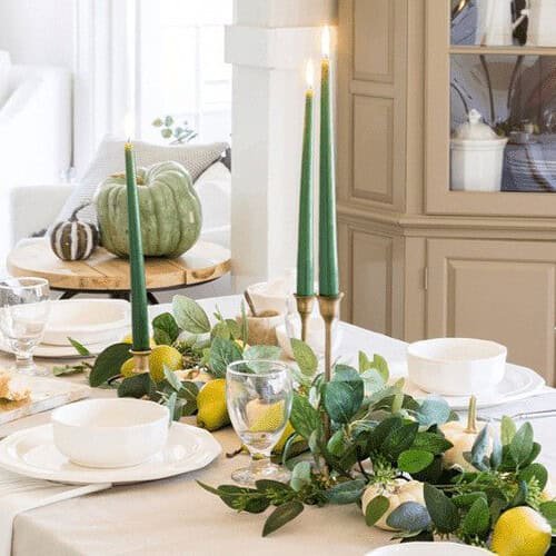 Fall table with eucalyptus runner, pears, white pumpkins and green taper candles