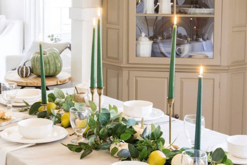 Thanksgiving table with pears, mini white pumpkins, eucalyptus and green taper candles