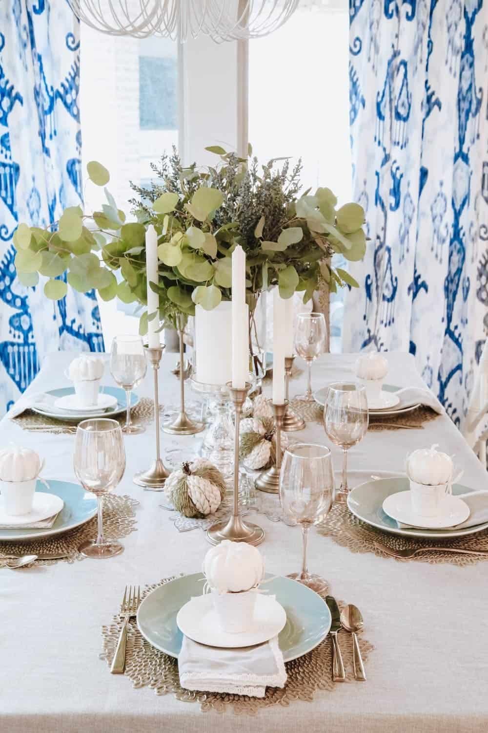 White and gold pumpkin Thanksgiving tablescape with a sequined runner and gold taper candles
