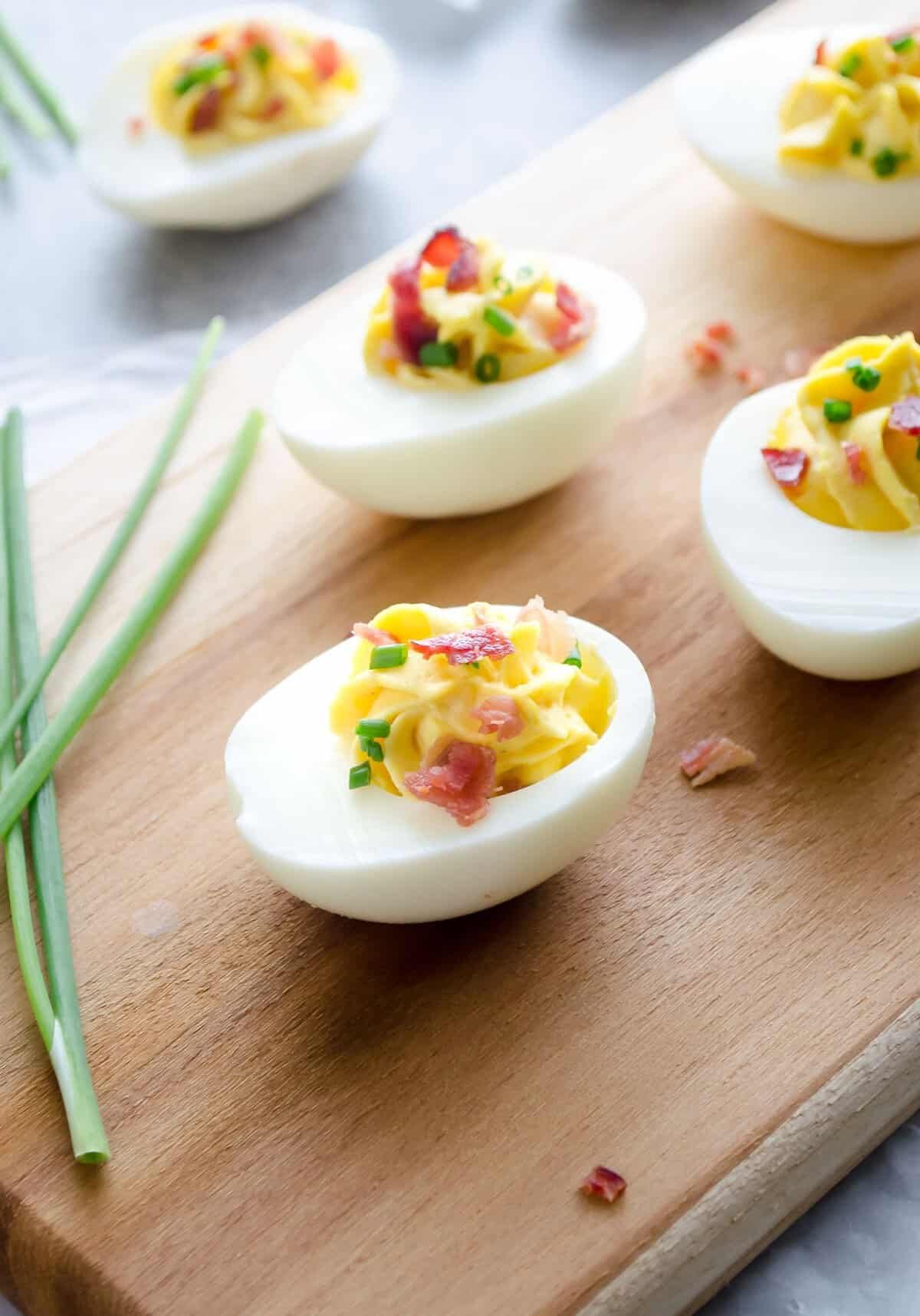Deviled eggs topped with bacon and chives