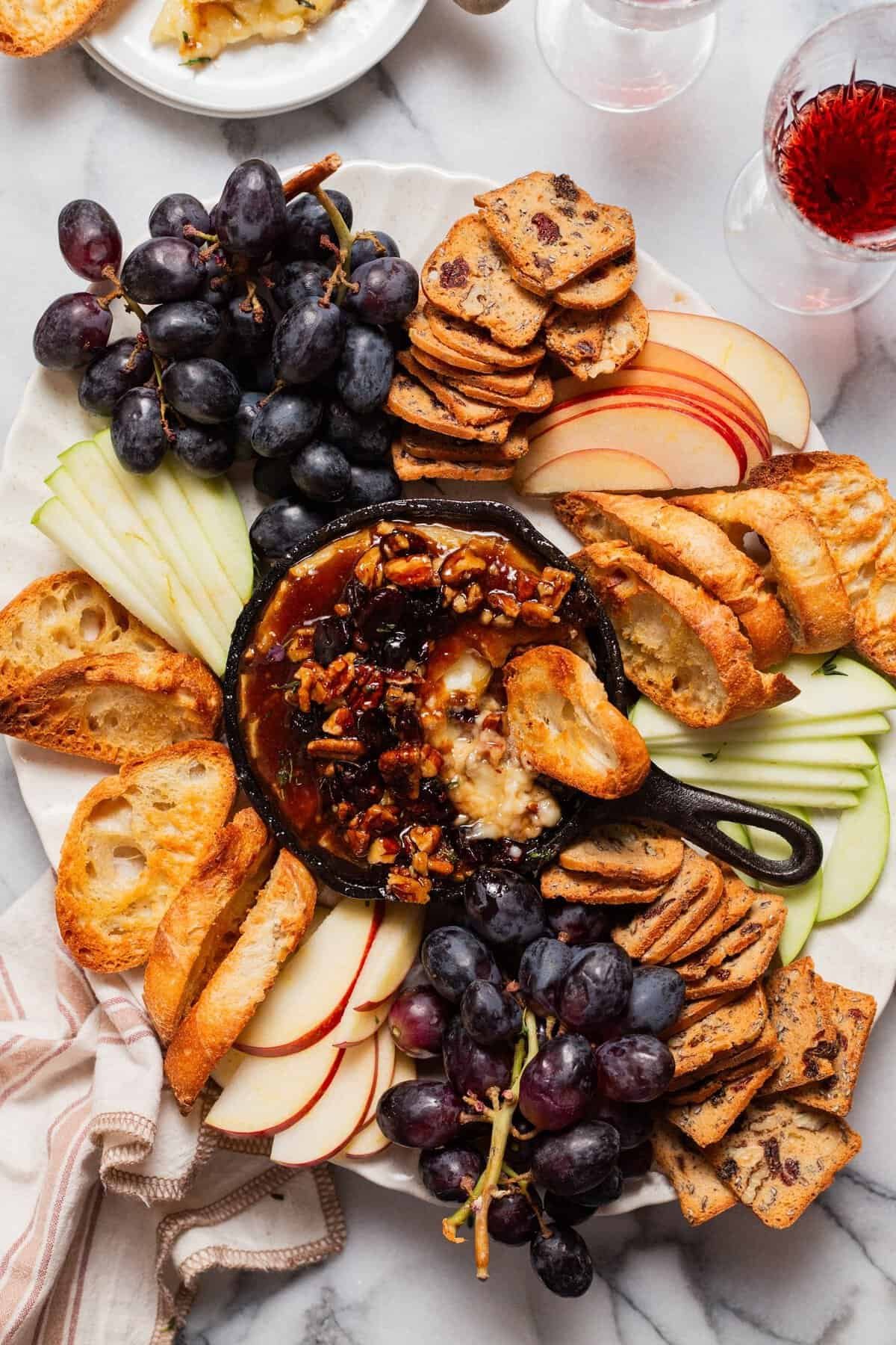 Baked brie topped with cranberries, pecans and honey