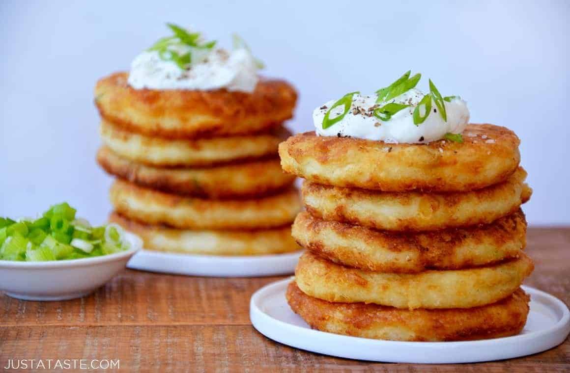 Golden cheesy mashed potato pancakes topped with sour cream and scallions