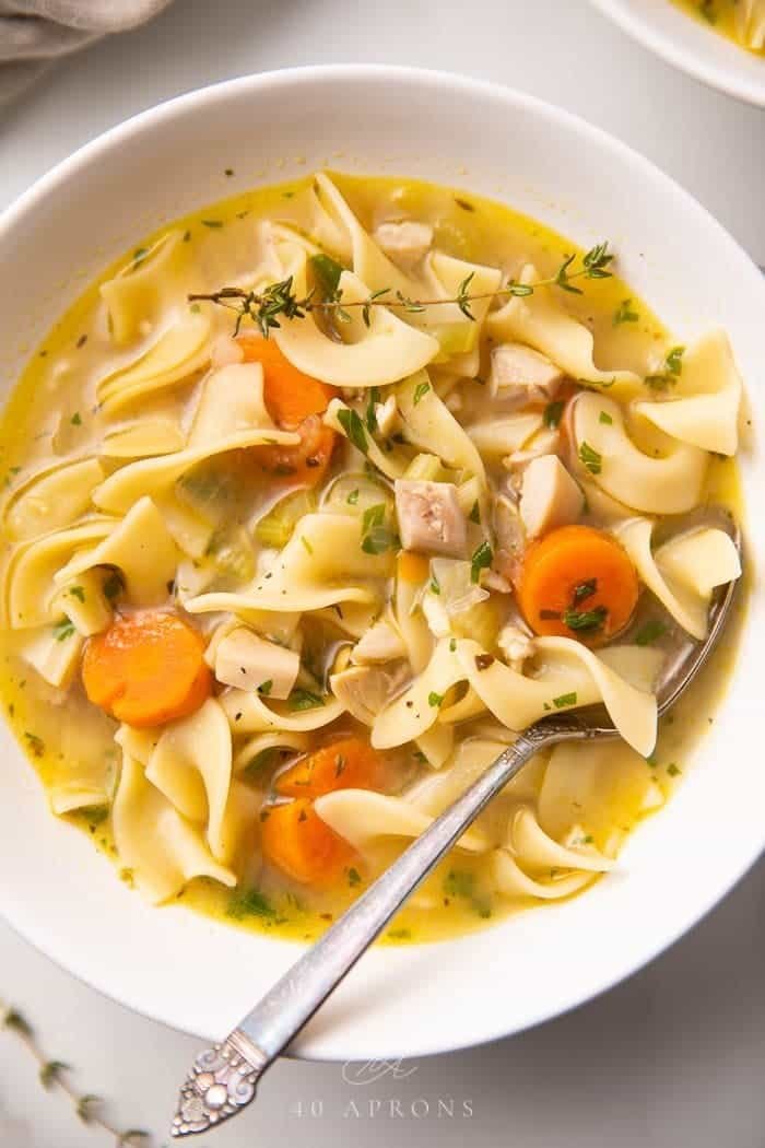 Bowl of turkey noodle soup with carrots, celery and egg noodles